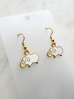 Kawaii Sheep-shaped earrings on a white card with a marble background