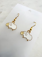 Kawaii Sheep-shaped earrings on a white card with a marble background