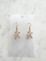 Pink Christmas Reindeer-shaped earrings on a white card with a marble background