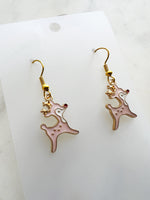 Pink Christmas Reindeer-shaped earrings on a white card with a marble background