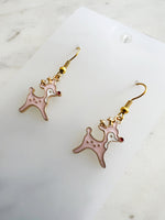 Pink Christmas Reindeer-shaped earrings on a white card with a marble background