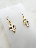 Kawaii Cat-shaped earrings on a white card with a marble background