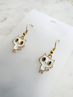 Kawaii Cat-shaped earrings on a white card with a marble background