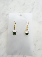 Kawaii Cupcake-shaped earrings on a white card with a marble background