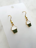 Kawaii Cupcake-shaped earrings on a white card with a marble background