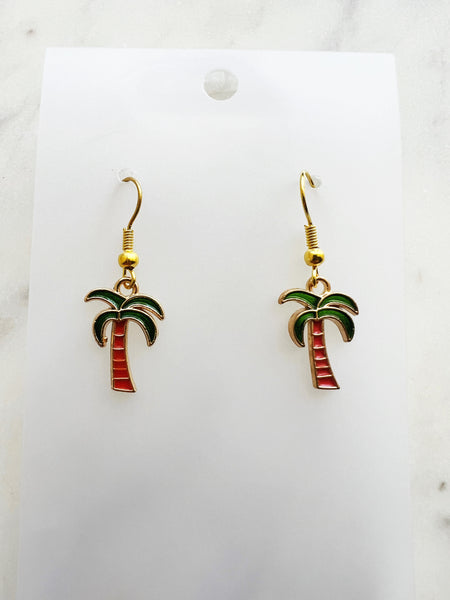 Kawaii Palm tree earrings on a white card with a marble background