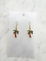Kawaii Palm tree earrings on a white card with a marble background