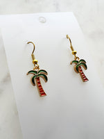 Kawaii Palm tree earrings on a white card with a marble background