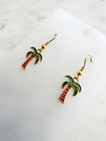 Kawaii Palm tree earrings on a white card with a marble background