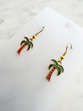 Kawaii Palm tree earrings on a white card with a marble background