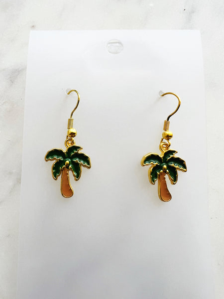 Kawaii Palm tree earrings on a white card with a marble background