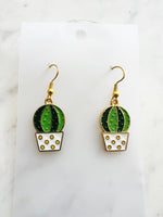 Kawaii Cactus-shaped earrings on a white card with a marble background