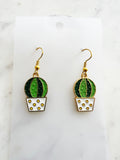 Kawaii Cactus-shaped earrings on a white card with a marble background
