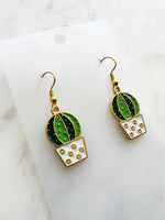 Kawaii Cactus-shaped earrings on a white card with a marble background