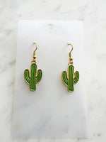 Kawaii Cactus-shaped earrings on a white card with a marble background
