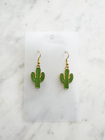 Kawaii Cactus-shaped earrings on a white card with a marble background