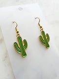 Kawaii Cactus-shaped earrings on a white card with a marble background