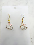 Pair of Kawaii bunny-shaped earrings on a white card with a marble background
