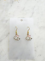 Pair of Kawaii bunny-shaped earrings on a white card with a marble background