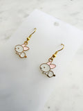 Pair of Kawaii bunny-shaped earrings on a white card with a marble background