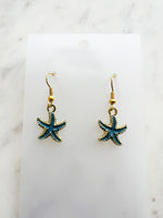 Kawai Starfish-shaped earrings on a marble surface