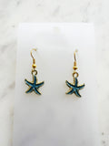Kawai Starfish-shaped earrings on a marble surface