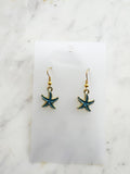 Kawai Starfish-shaped earrings on a marble surface