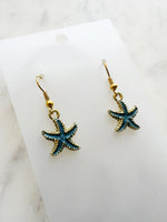 Kawai Starfish-shaped earrings on a marble surface