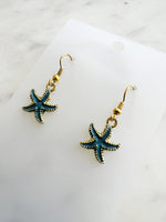 Kawai Starfish-shaped earrings on a marble surface