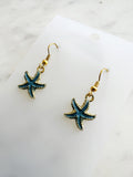 Kawai Starfish-shaped earrings on a marble surface