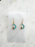 Kawaii Earrings with cat and moon design on a white card with a marble surface