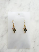 Kawaii Cactus-shaped earrings on a white card with a marble background