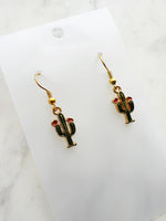 Kawaii Cactus-shaped earrings on a white card with a marble background