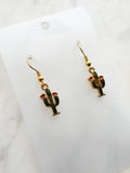 Kawaii Cactus-shaped earrings on a white card with a marble background