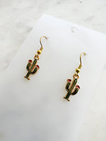 Kawaii Cactus-shaped earrings on a white card with a marble background