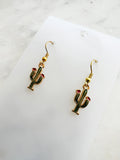 Kawaii Cactus-shaped earrings on a white card with a marble background