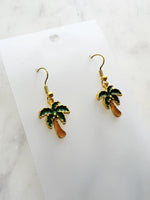Kawaii Palm tree earrings on a white card with a marble background