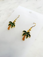 Kawaii Palm tree earrings on a white card with a marble background