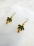 Kawaii Palm tree earrings on a white card with a marble background