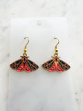 Kawaii Moth earrings on a white card with a white marble background