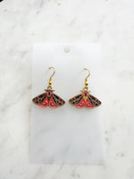 Kawaii Moth earrings on a white card with a white marble background