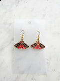 Kawaii Moth earrings on a white card with a white marble background