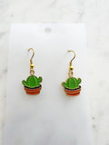 Kawaii Cactus-shaped earrings on a white card with a marble background