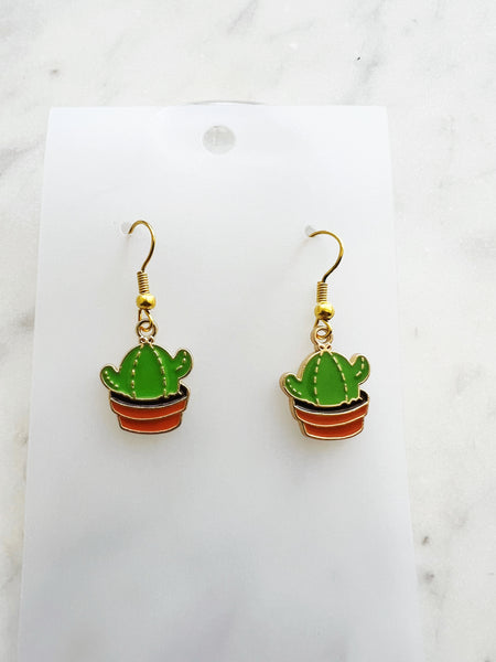 Kawaii Cactus-shaped earrings on a white card with a marble background