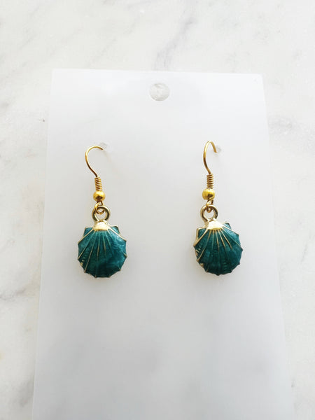 Teal earrings with gold hooks on a marble background
