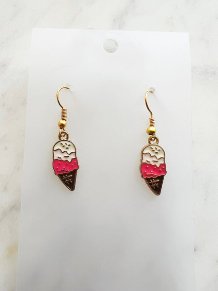 ice cream cone shaped earrings on a marble background