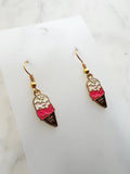 ice cream cone shaped earrings on a marble background