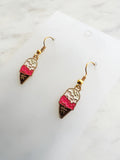 ice cream cone shaped earrings on a marble background