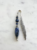 Handmade feather bookmark with deep blue sodalite crystal beads and Tibetan silver feather, displayed on a marble background.