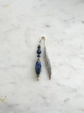 Handmade feather bookmark with deep blue sodalite crystal beads and Tibetan silver feather, displayed on a marble background.